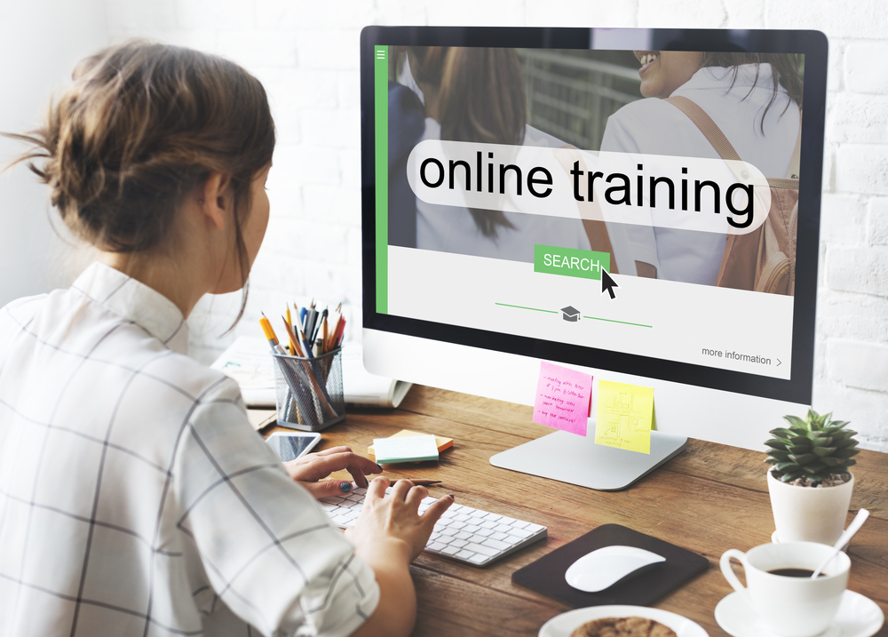 A woman sitting in front of a computer with the words online training on the screen 